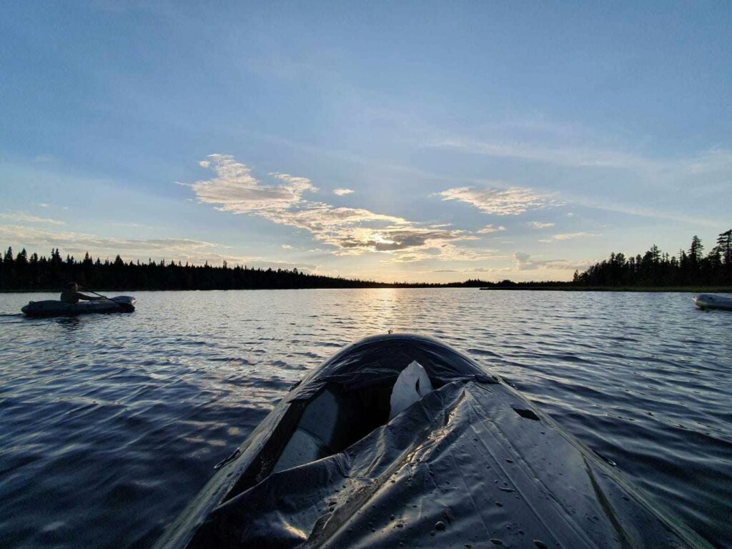 Packraft sur l'eau calme au soleil de minuit