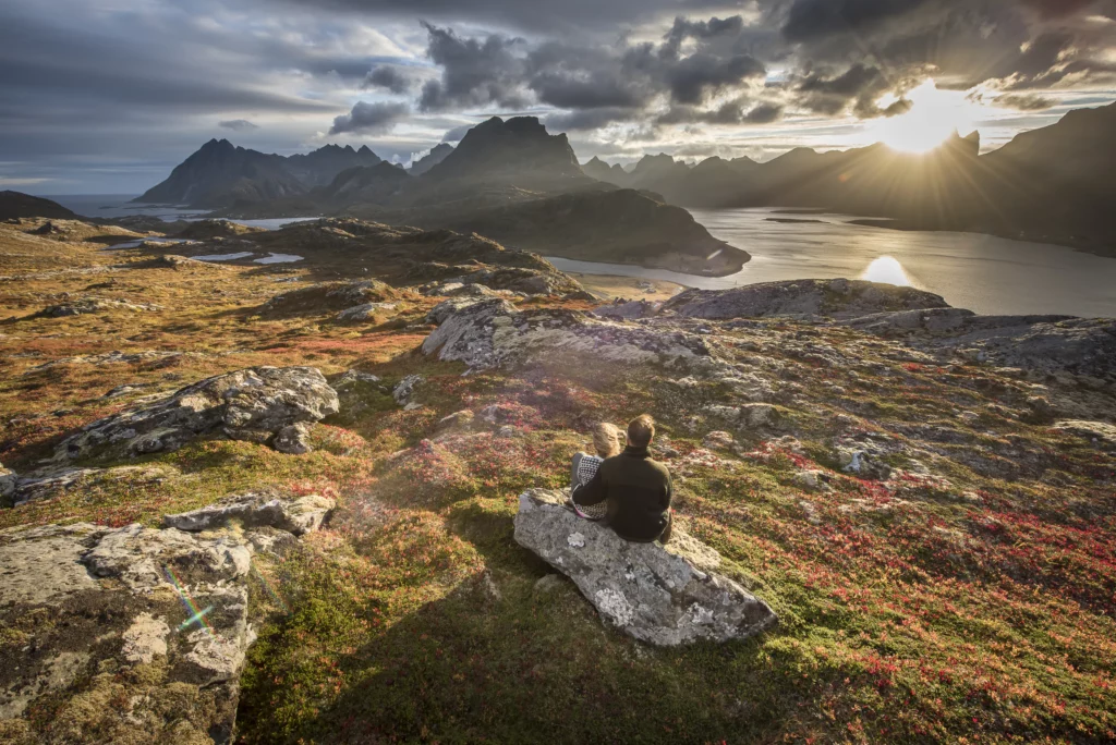 Randonneur face aux montagnes et au fjord en automne